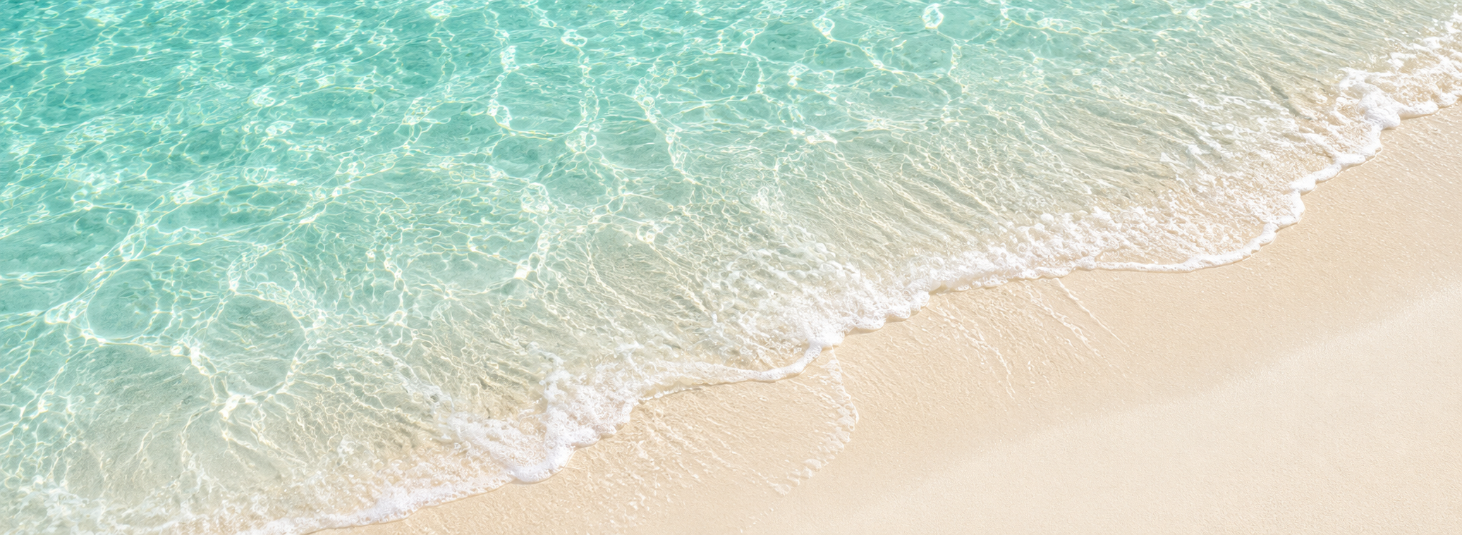 Clear turquoise water meeting a soft sandy beach
